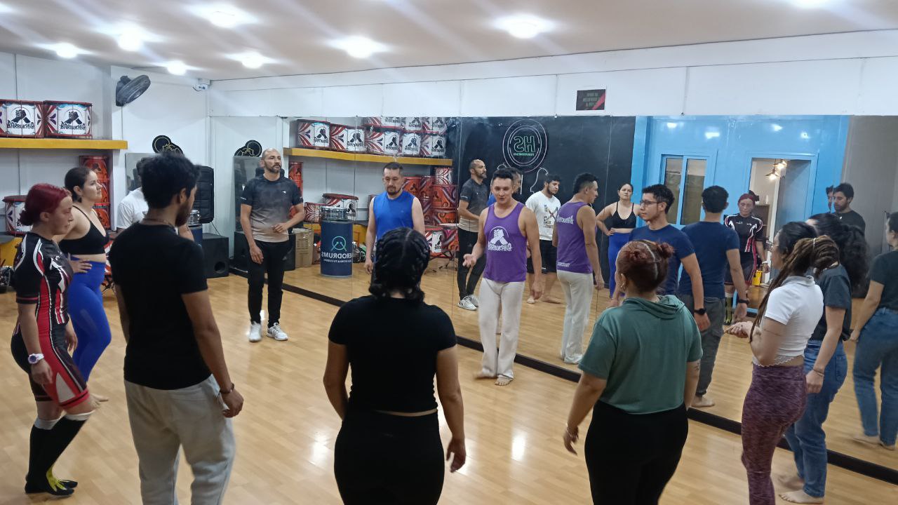 Fotografía de un taller con varias personas en un salón de espejos