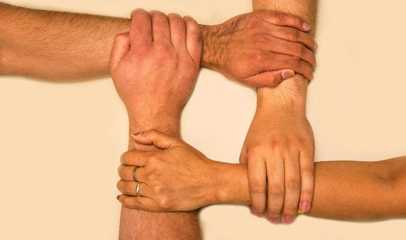 Cuatro manos - brazos unidos, los cuales están unidos formando un cuadrado a través de mano unida con la muñeca del otro