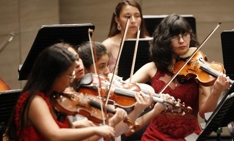 mujeres de la filarmónica tocando instrumentos