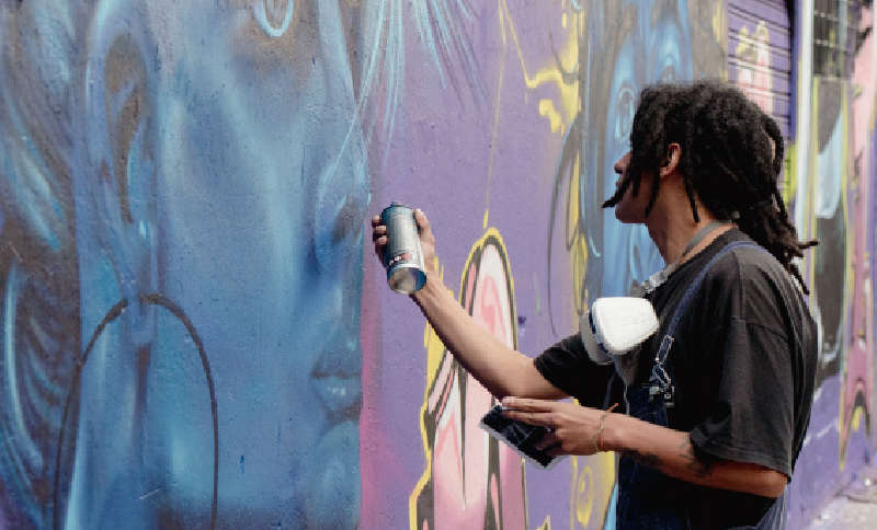 Joven haciendo un grafiti en un muro 