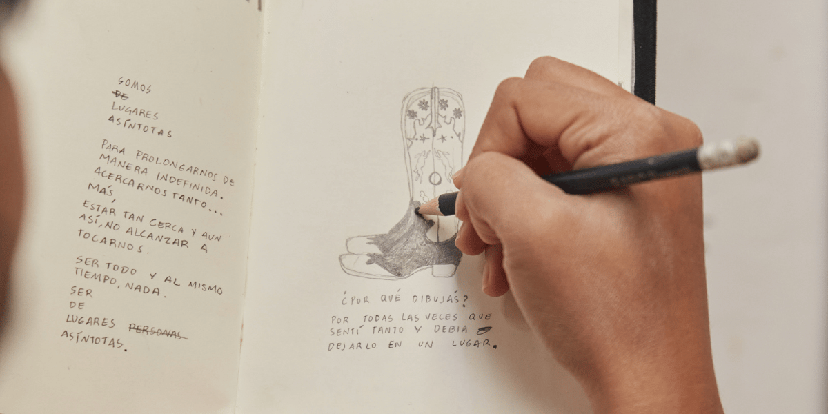 Una mano dibujando sobre una libreta