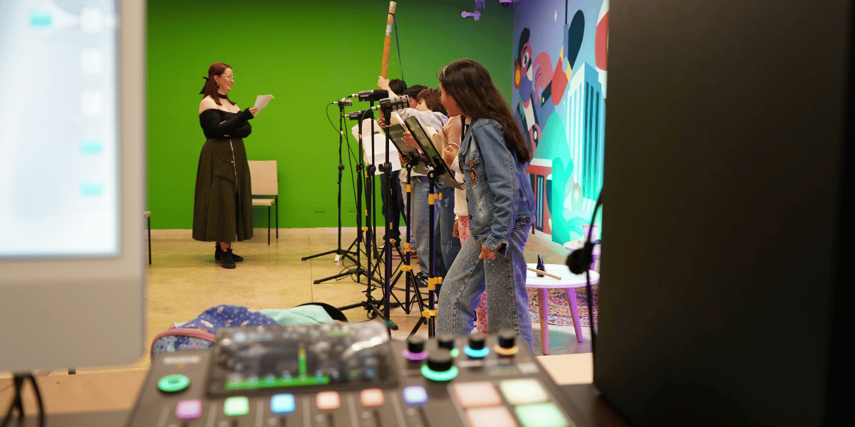 Fotografía de varias niñas y niños grabando su voz en un estudio de grabación