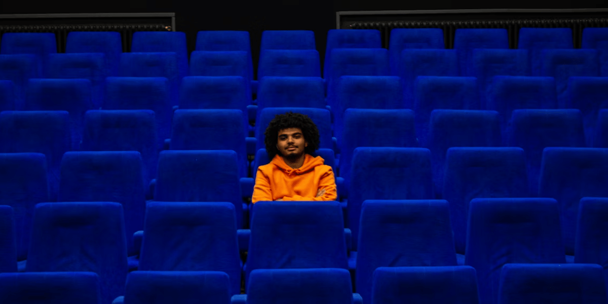 Una persona sentada en medio de una sala de cine