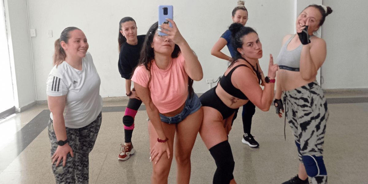 Mujeres tomando una fotografía en un espejo de un salón de baile