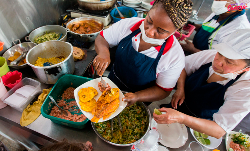 Mujer sirviendo un pescado en un plato