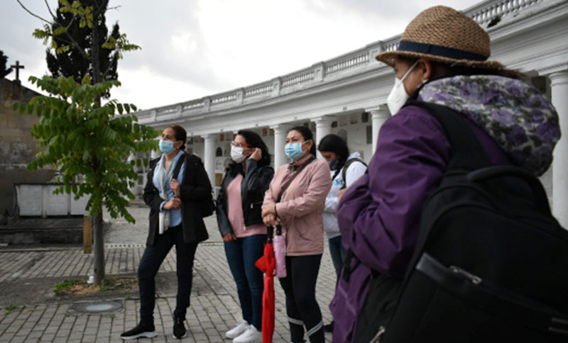 Personas escuchando una información en un cementerio