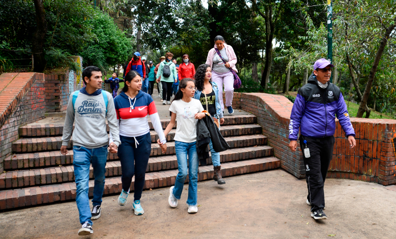 Personas realizando caminata con instructor del IDRD