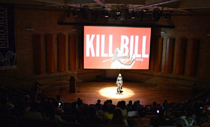 Personas en una biblioteca viendo una proyección de cine