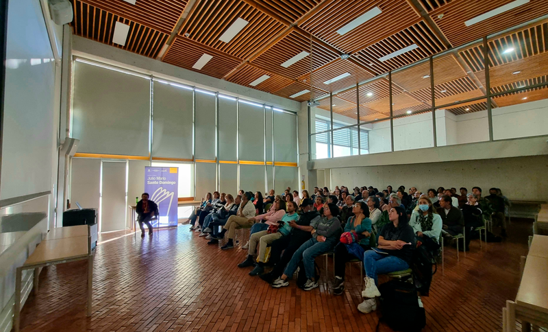 Personas viendo hacia una pantalla en una biblioteca
