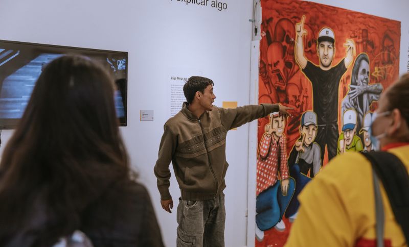 Joven exponiendo una obra