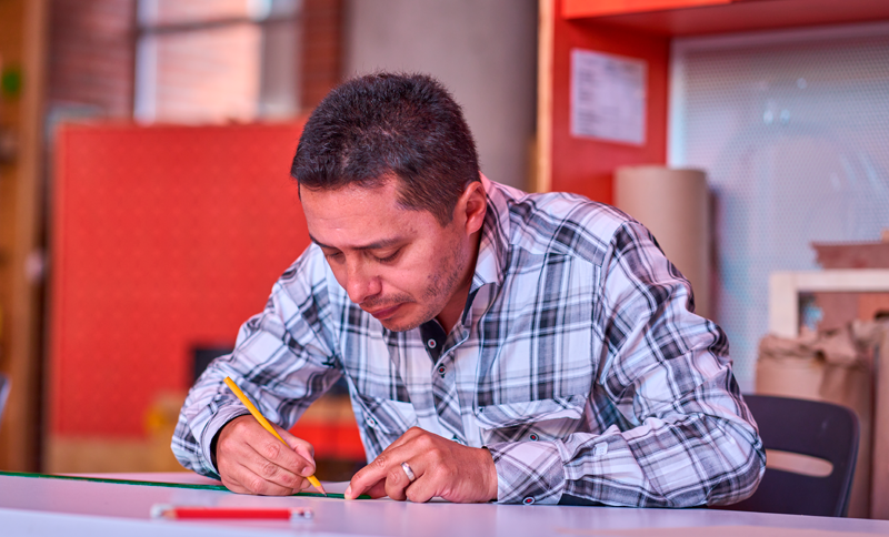 Hombre escribiendo con un lápiz en un cuaderno