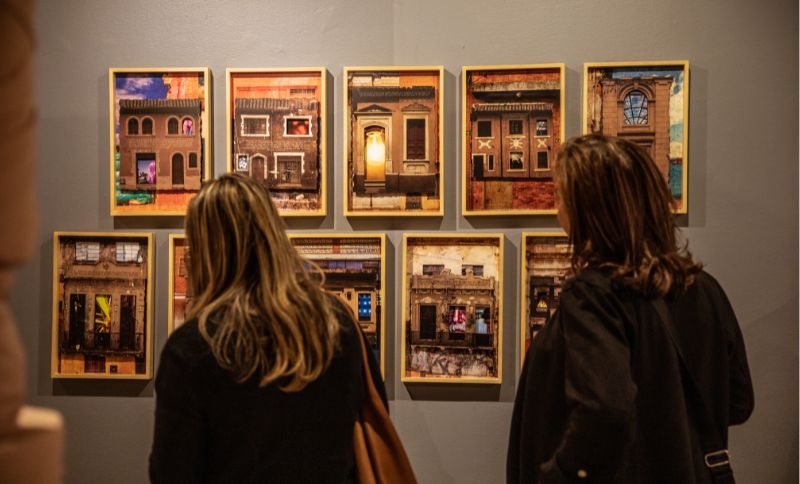 Mujeres apreciando cuadros en exposición
