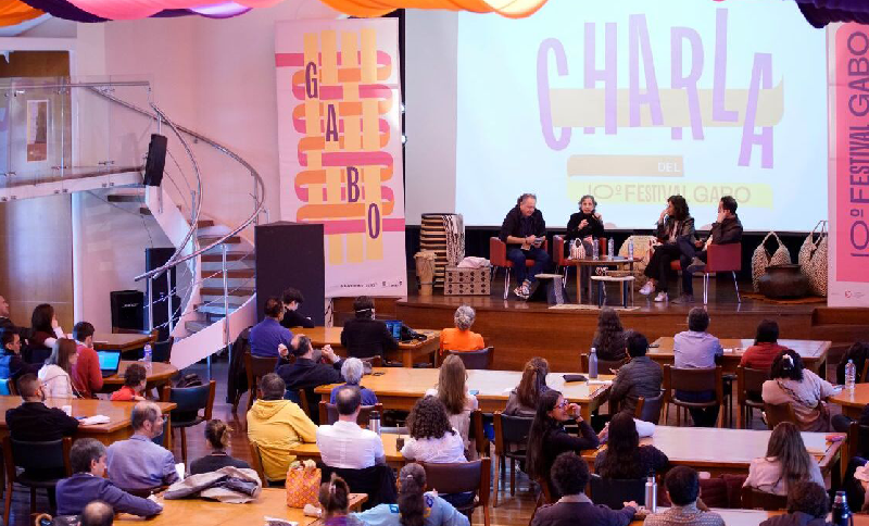 Personas reunidas en un escenario asistiendo a una charla