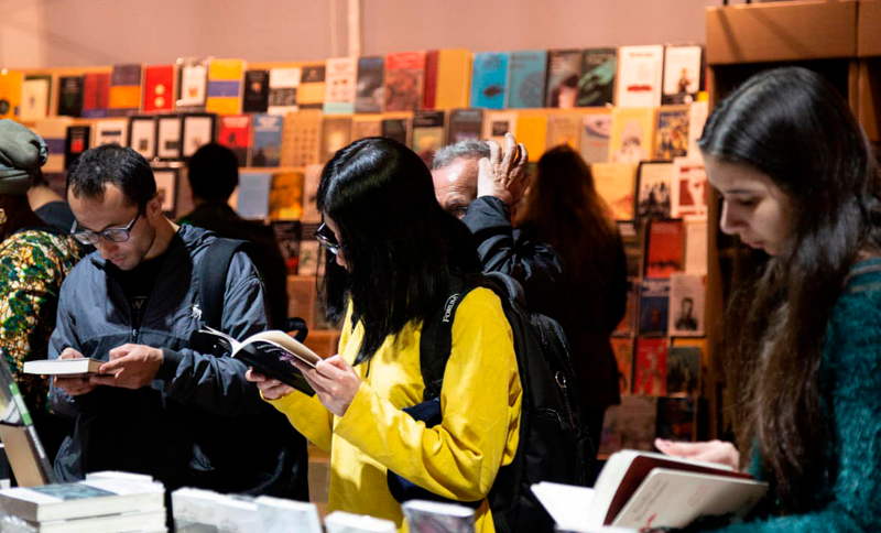 Personas leyendo libros en una feria