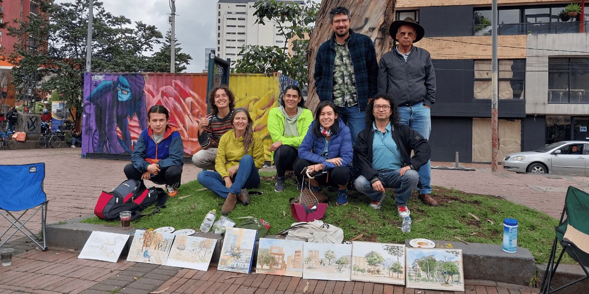 Participantes del taller con sus acuarelas al frente.