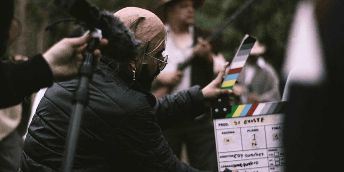 Personaje con una claqueta de cine, iniciando una escena.               
