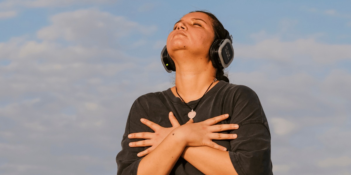 Mujer meditando con audífonos.