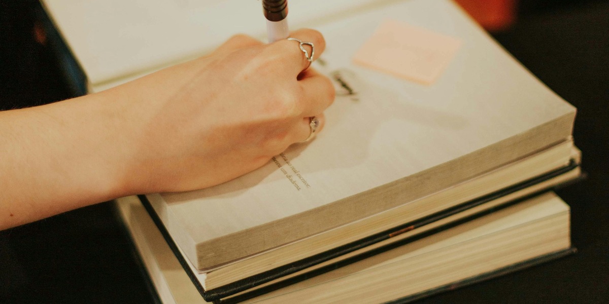 Persona escribiendo sobre un libro.