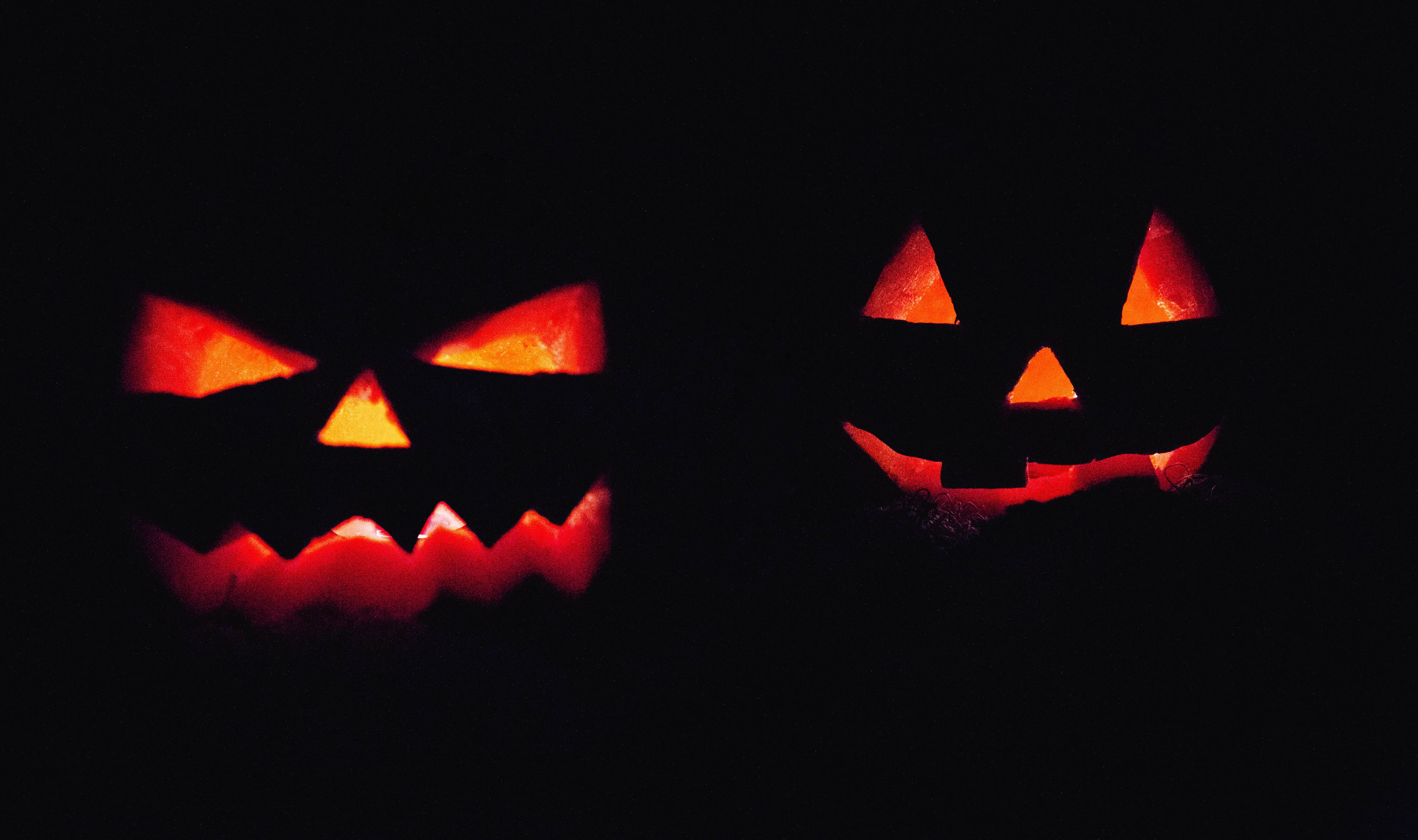 Fotografía de dos calabazas con luz interior en un escenario oscuro