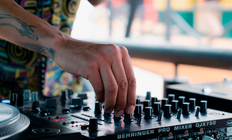 Foto de una mano en un equipo mezclador de sonido