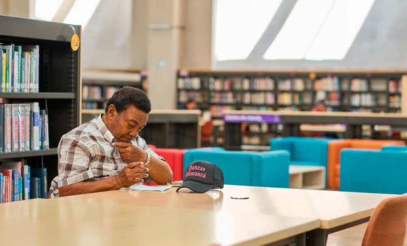 Hombre leyendo en una Biblioteca