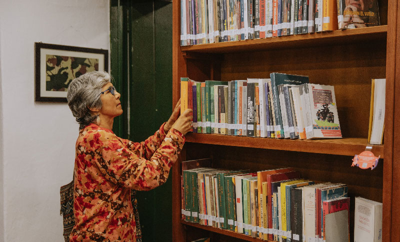 Mujer tomando un libro de una biblioteca