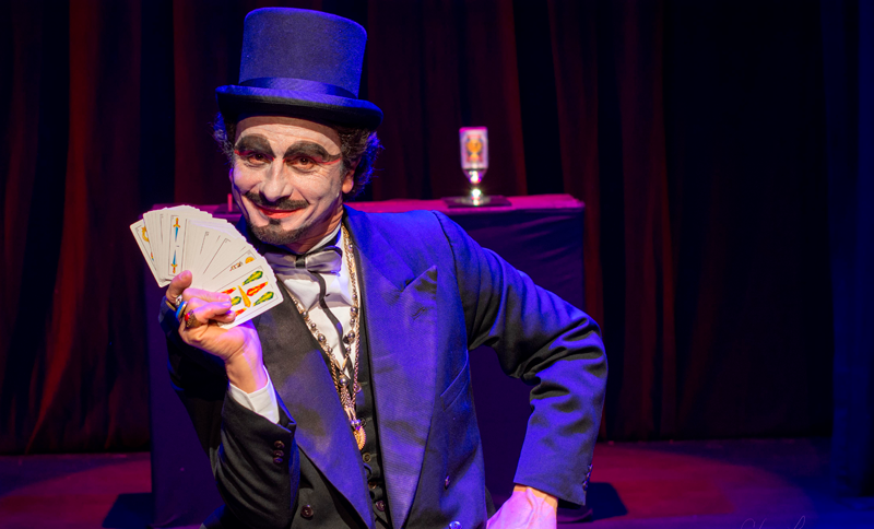 Ilusionista con un mano de cartas en la mano
