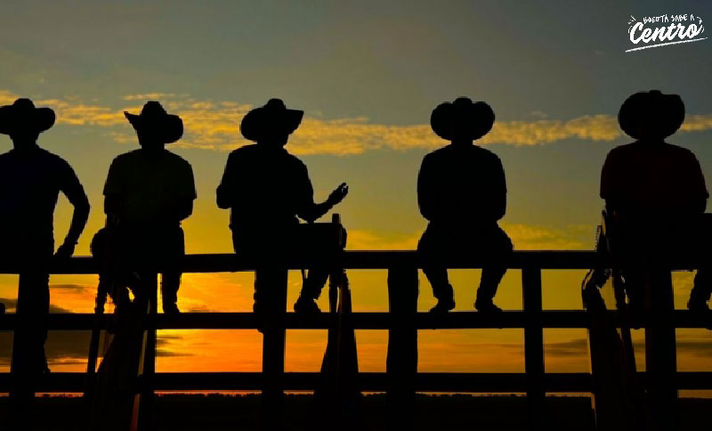 silueta de hombres con sombrero y el atardecer de fondo