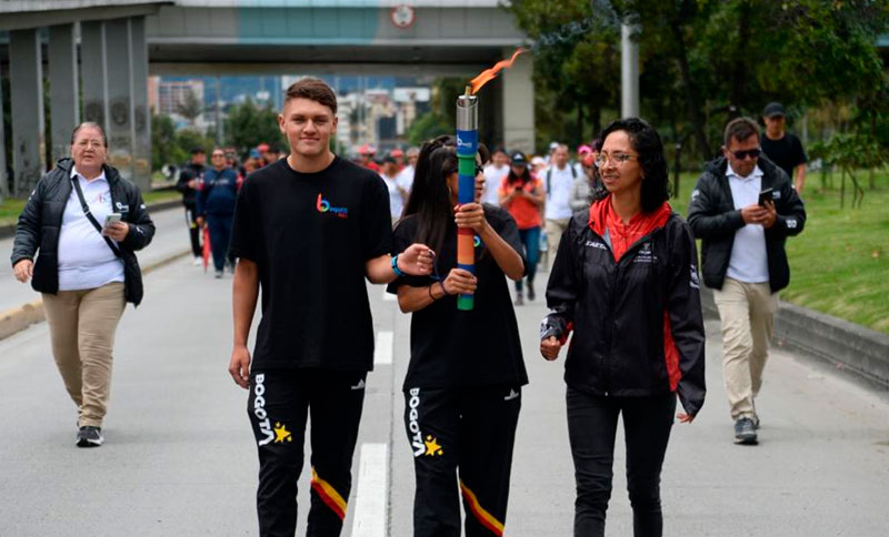 Personas caminando y una mujer llevando una antorcha en la mano 