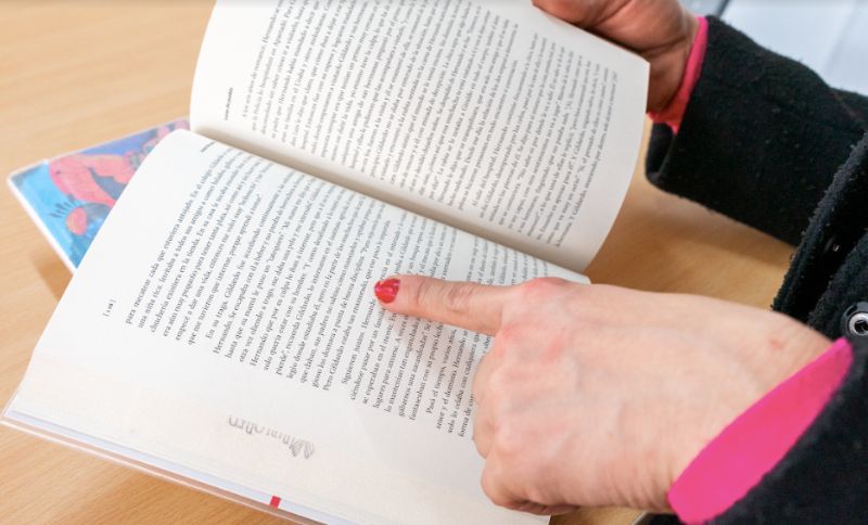 Mano de mujer señalando un párrafo de un libro