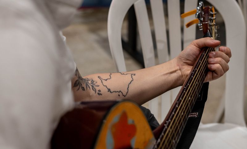Brazo de un hombre tocando guitarra