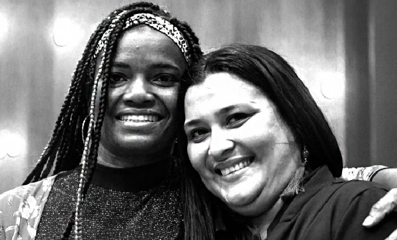 Dos mujeres abrazadas sonriendo ante la cámara