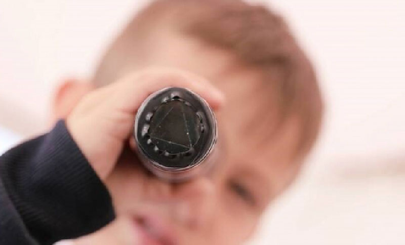 Niño mirando por un telescopio de juguete
