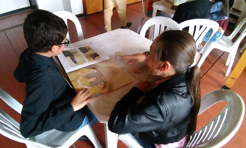dos niños leyendo un libro