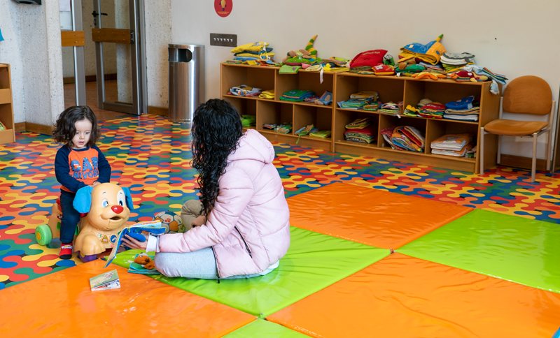 Mama e hija en una sala infantil de unja biblioteca