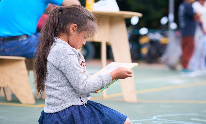 Niña leyendo en un espacio abierto