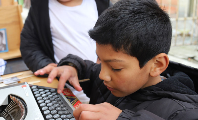Niño escribiendo en una máquina de escribir