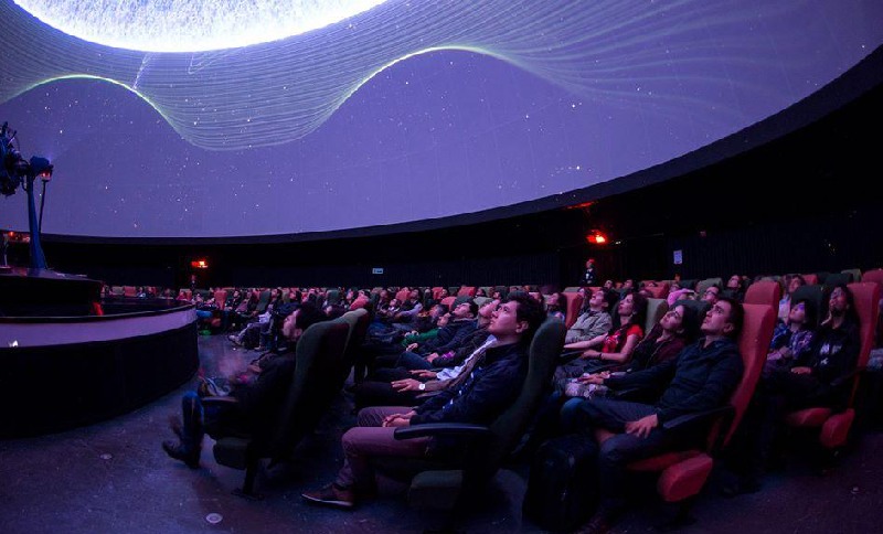 Persones viendo una proyección audiovisual en un domo