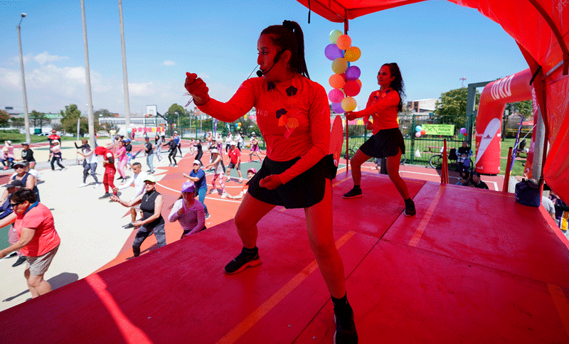 Instructora de deporte dirigiendo una clase sobre una tarima