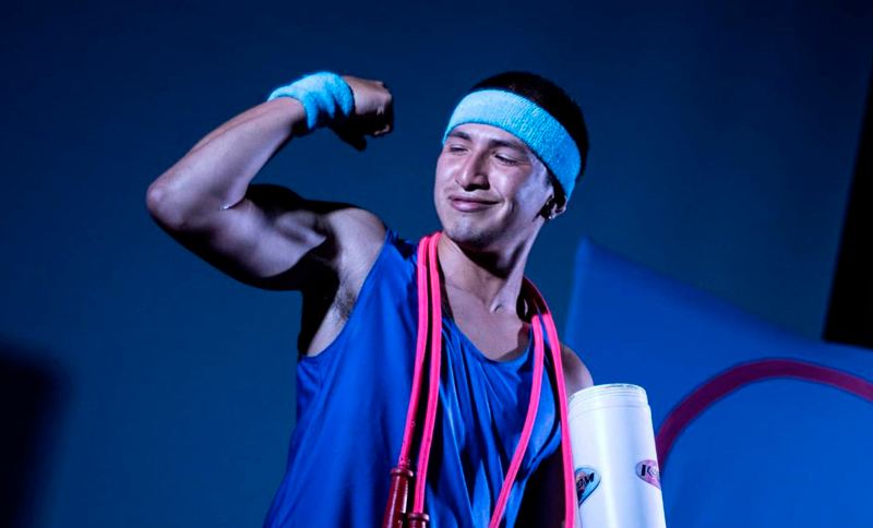 Hombre en un escenario exhibiendo sus musculos