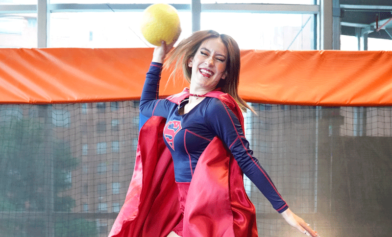 Mujer disfrazada saltando y con una pelota en la mano