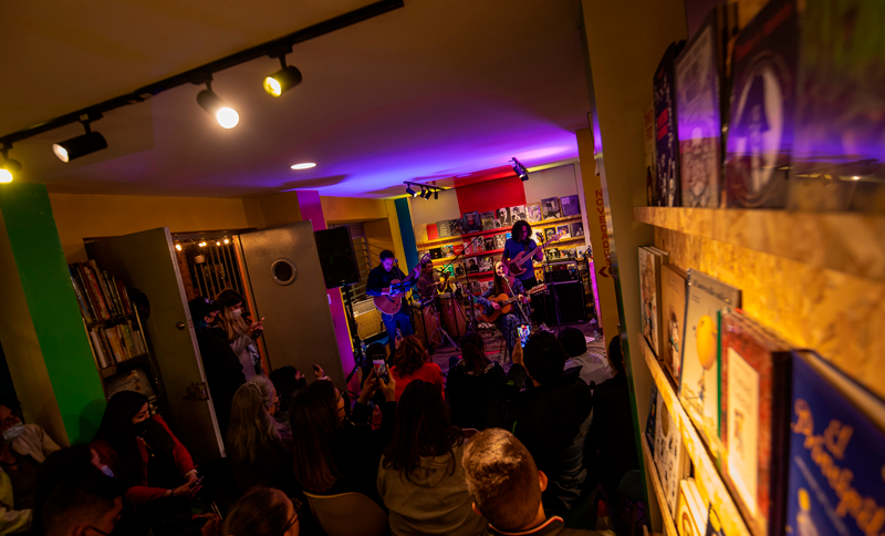 Personas reunidas en un recinto cerrado escuchando un concierto en vivo