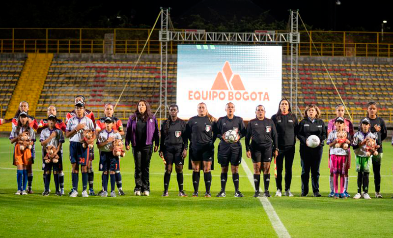 Mujeres árbitro, jugadoras y directora del IDRD en un estadio