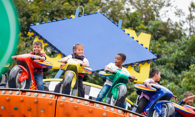 NIños y niñas en un parque de diversiones