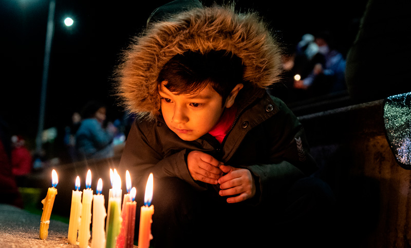 Niño mirando unas velitas encendidas