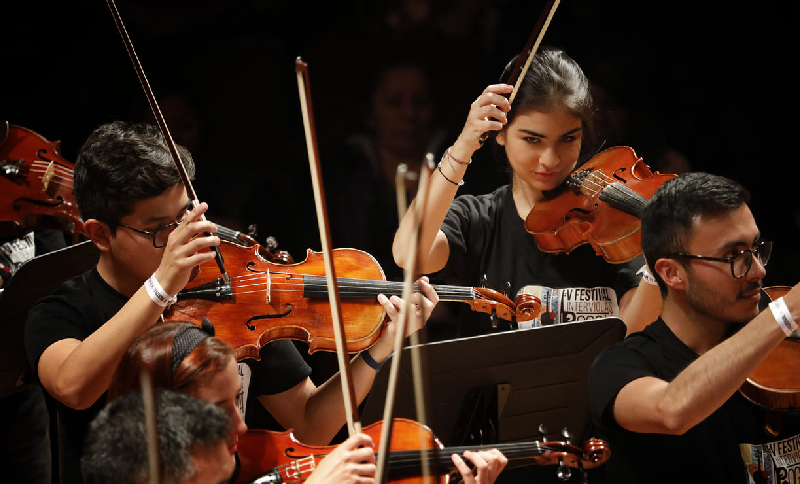 Jóvenes tocando violas en un escenario