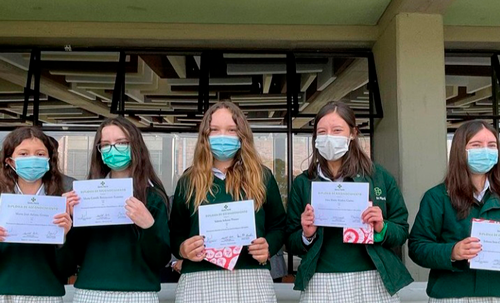 cinco mujeres estudiantes con diplomasen la mano