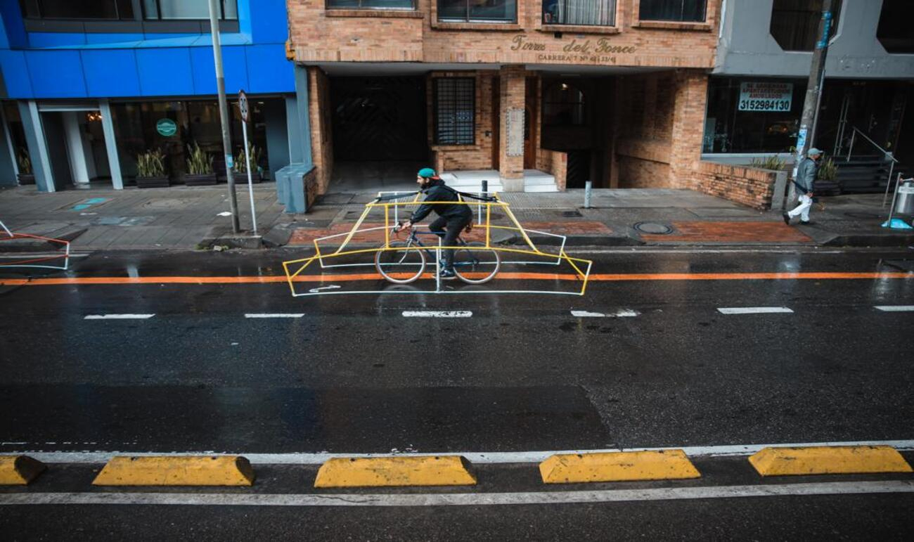 Persona en bicicleta con estructura tubular de carro