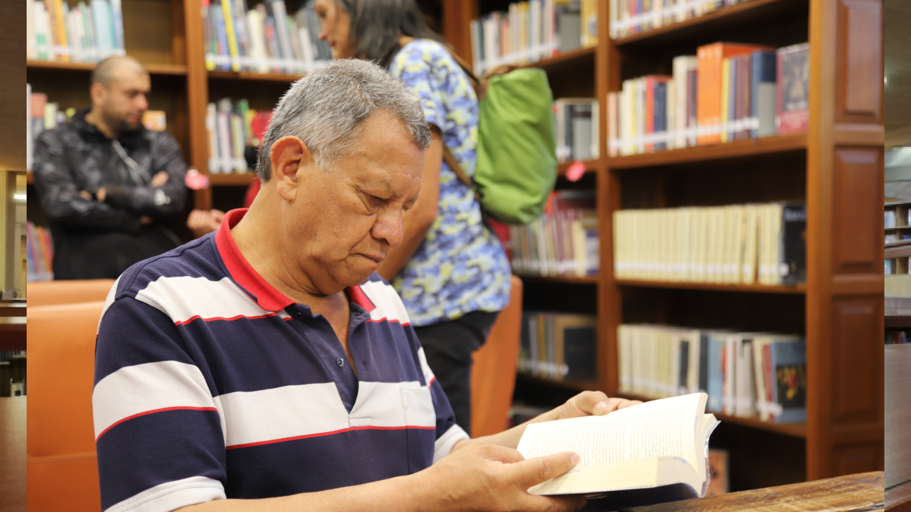 persona mayor leyendo en una biblioteca