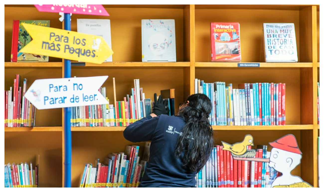 Mujer en una biblioteca buscando libro